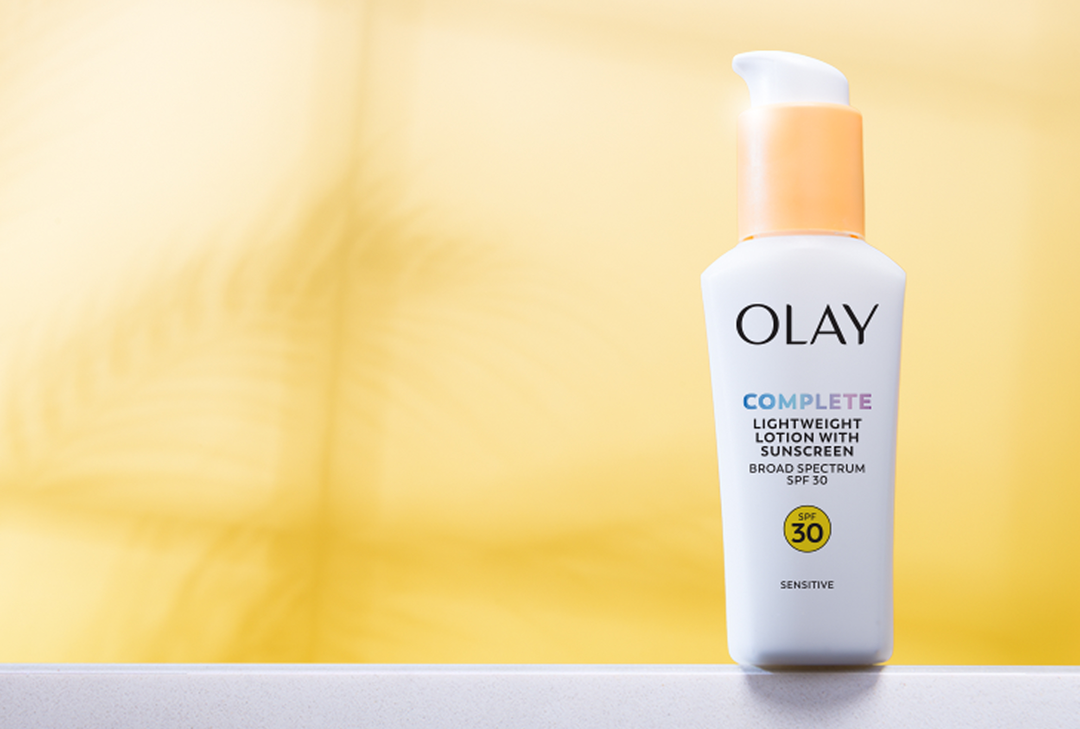 Bottle of Olay Complete Sensitive SPF 30 posed on a white marble countertop Bottle of Olay Complete Sensitive SPF 30 posed on a white marble countertop