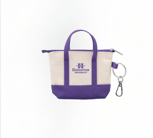 Mini canvas tote bag keychain with purple accents and has the Houghton University logo printed on the bag center in purple.
