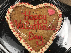 Giant heart cookie with frosting around edge and says "Happy Valentine's Day"