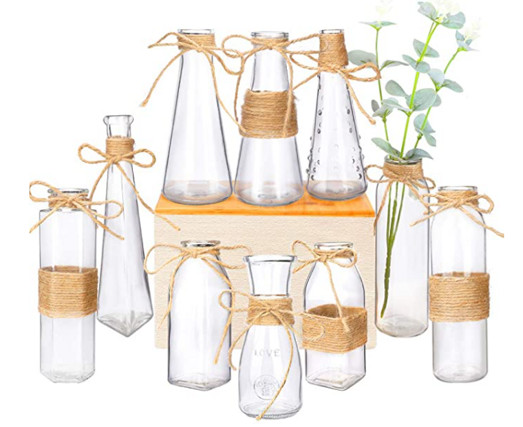 Assorted sizes of small glass vases with rope wrapped around the middle or top.