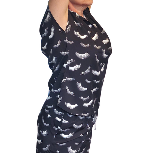 Lash technician wearing lash print scrubs jogger set in salon environment