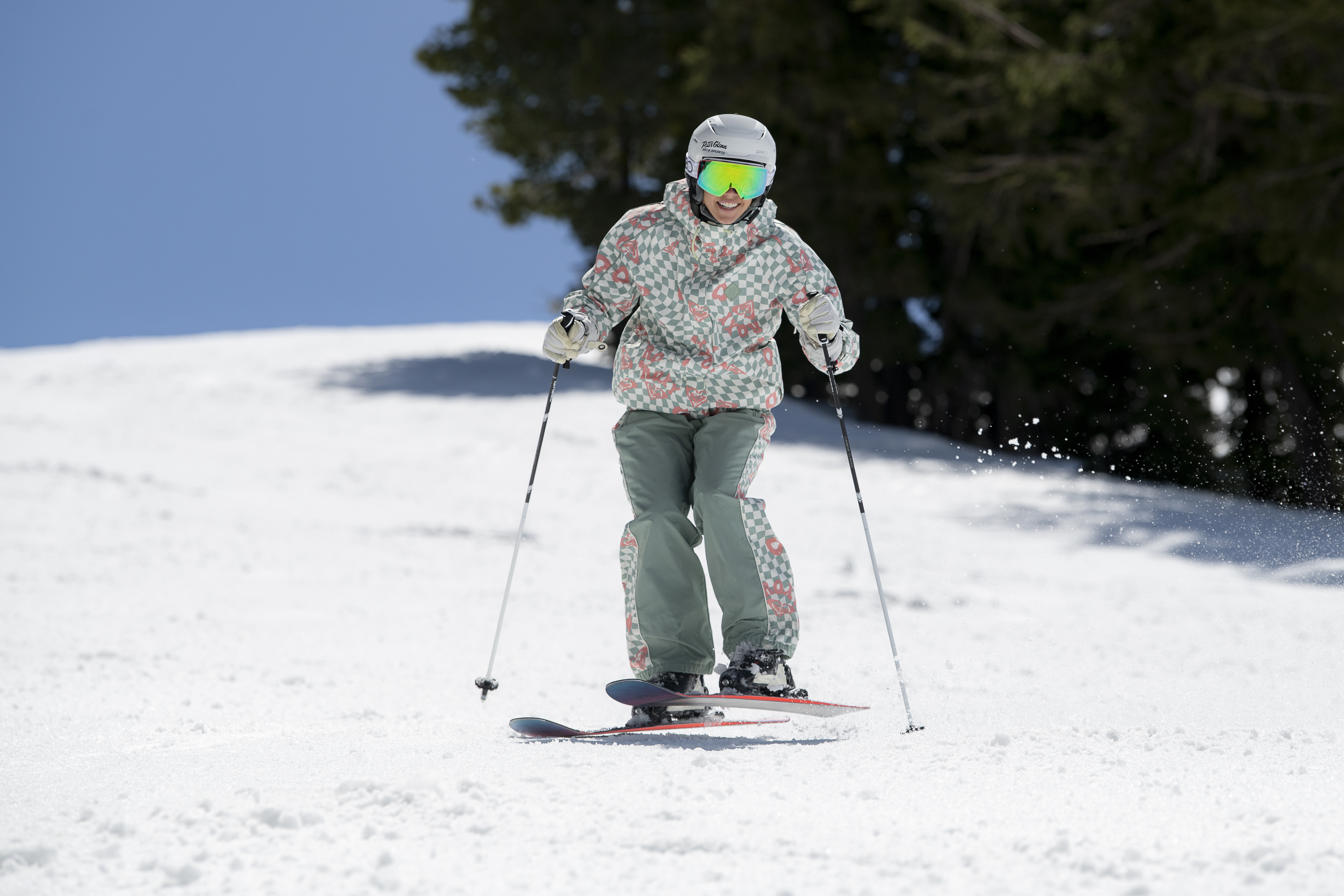 woman skiing down mountain doing a jump