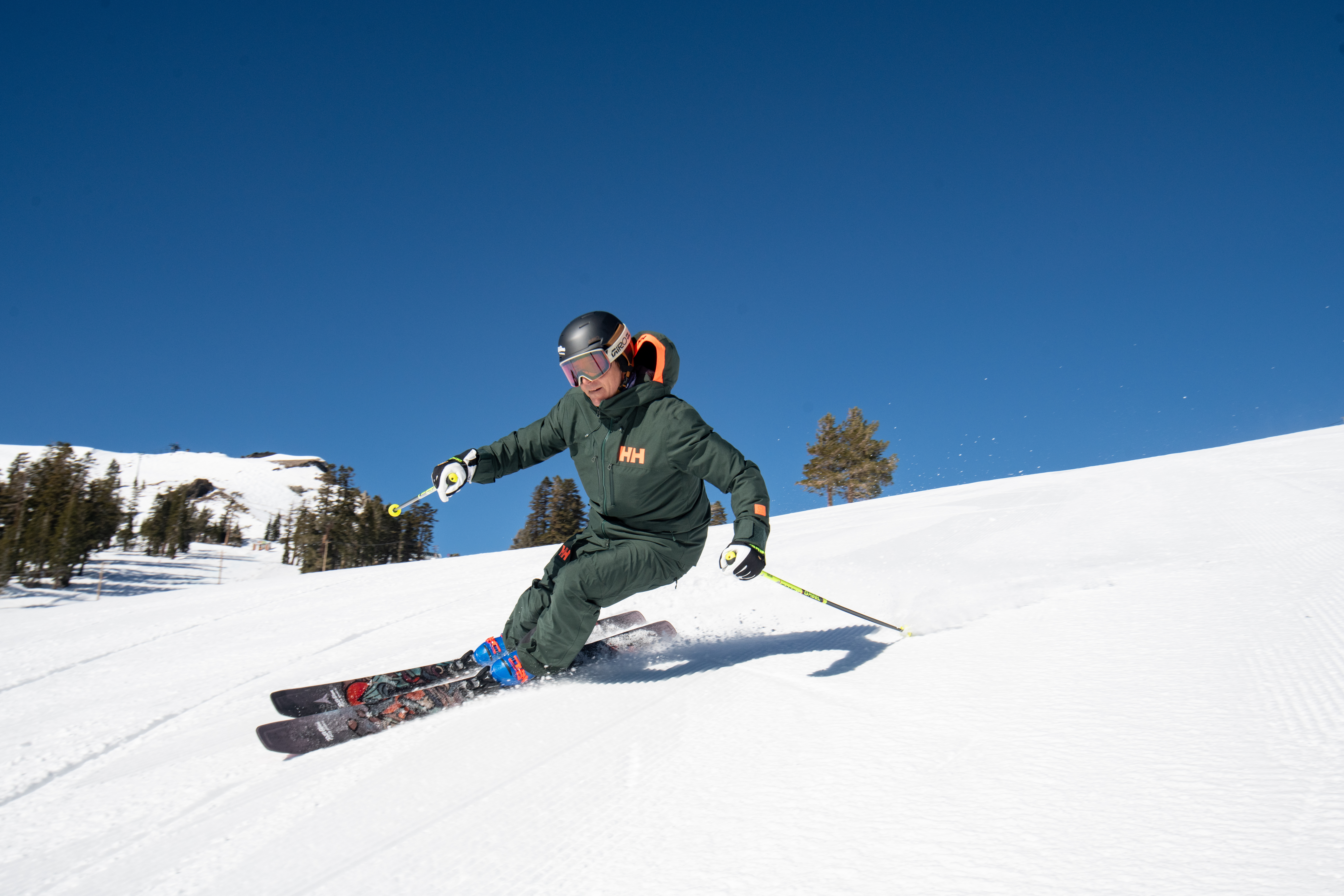 man skiing down mountain holding ski poles