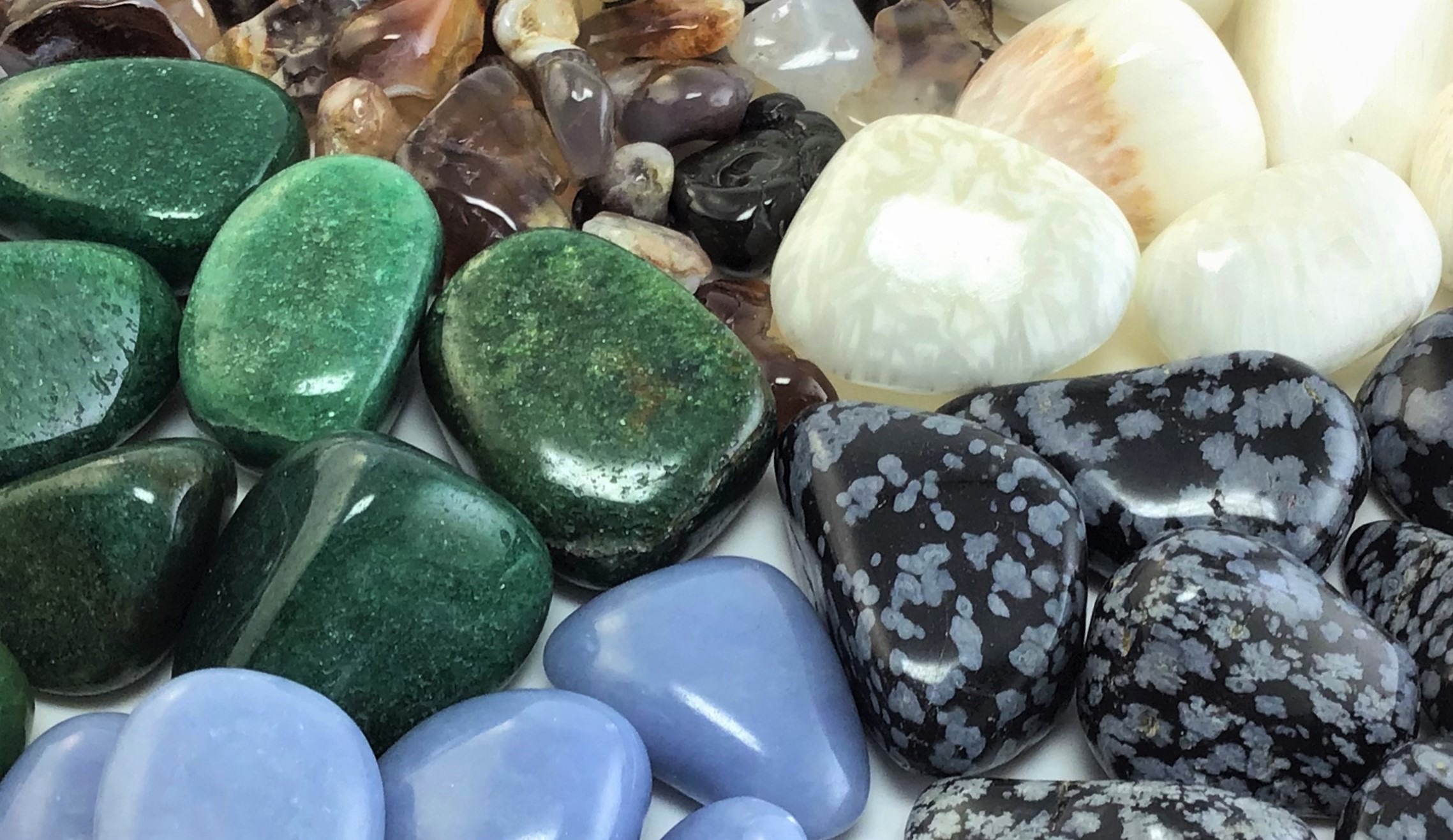 Tumbled crystals for the holiday season in a radial pattern, including Angelite, Fire Agate, Fuchsite, Scolecite, and Snowflake Obsidian.