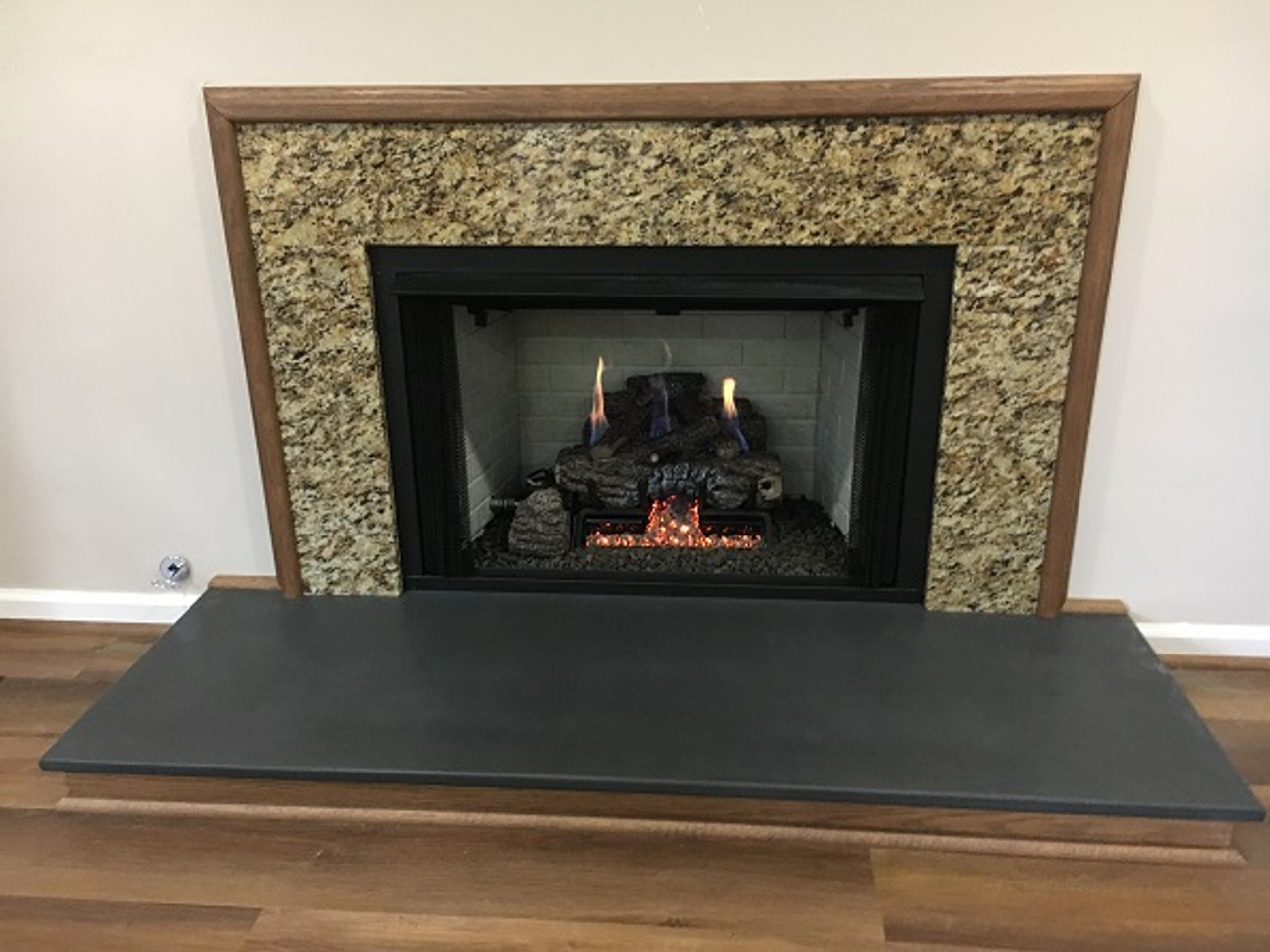 Black slate fireplace hearth with square eased honed edges and top.