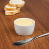 Whiteware Butter Dish 62mm with content together with bread knife and toasted bread in the table.