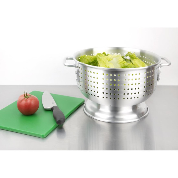 Vogue Aluminium Colander 16" with lettuce content beside green chopping board with knife and tomato on top.