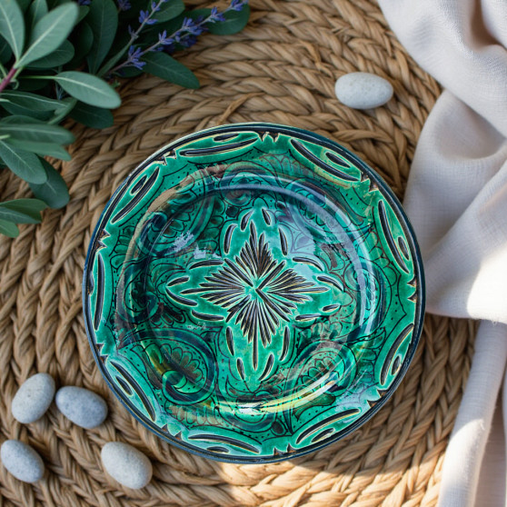 Handmade Moroccan pottery plate with deep green glaze and leafy hand-painted motifs