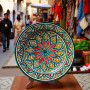 Handmade Moroccan pottery plate with vibrant red, yellow, and green geometric star pattern Glow and Clay