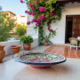 Handmade Moroccan ceramic plate with vibrant red, blue, green, and yellow patterns Glow and Clay