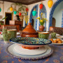 Handmade Moroccan pottery plate with red, blue, yellow, and green geometric design Glow and Clay