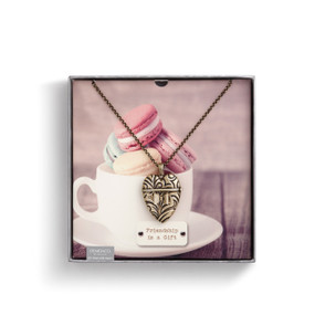 Small square box with white coffee cup and pink macaroons printed on - silver heart pendant necklace with 'friendship is a gift' under it