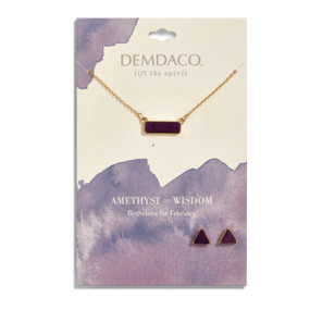 Gold necklace holds a rectangular pendant with a dark purple stone. Gold, triangular stud earrings have dark purple stones. Both necklace and earrings are on a white message card with purple accents