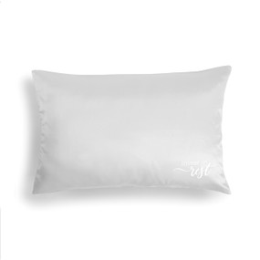 light gray satin pillow with 'invest in rest' in white letters in right bottom corner