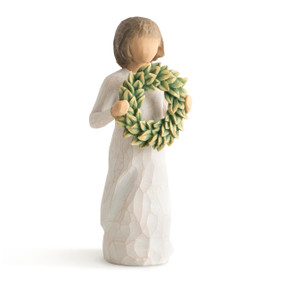 Front view of standing figure with short brown hair and bangs in cream dress holding wreath of green magnolia leaves at her chest