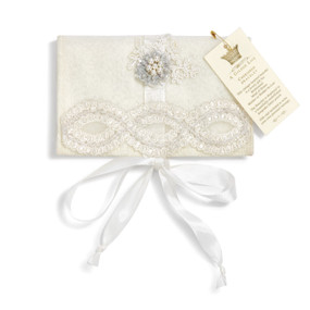 White drawstring pouch with infinity flower crystal designs, white bow on bottom, A Gilded Life tag in gold letters