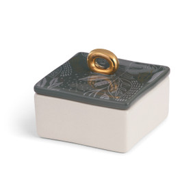 square ceramic box with black lid with light gray leaf outline pattern and round gold handle and white base