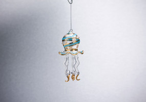 Hanging glass octopus figurine with blue/gold stripes on it