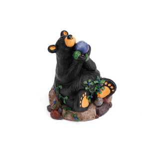 Black bear figurine sitting down holding blue ball