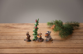 Racoon and squirel figurines around green tree - on wooden table