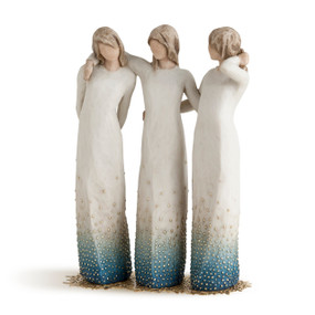 Three tall female figures with arms around each other attached to gold metal base, all wearing cream dresses with blue ombre and gold dots around base