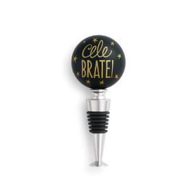 Bottle stopper has round, black top with gold colored dots and lettering. Bottom is metallic with black rubber.