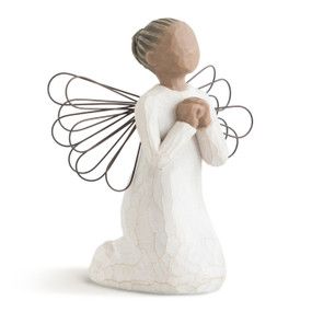 Front view of female angel in cream dress with wire wings, with darker skin and hair in bun, kneeling in prayer position