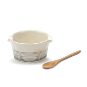 white ceramic dish with gray striped around outside next to wooden spoon