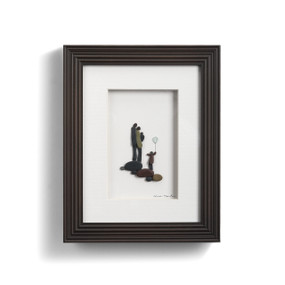 framed art made of pebbles depicting a couple with a baby next to a child holding a seglass balloon with arms in air