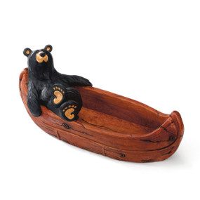 Small wooden canoe with black bear figurine sitting on the left side