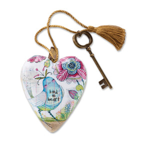 White heart with blue and white bird and a pink and blue flower. Bronze key and golden tassel are attached to top of heart
