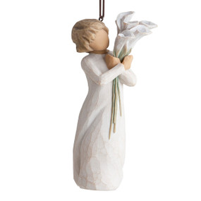 Front view of figure in cream dress with short hair holding tall bouquet of white calla lillies, ornament hook affixed to top of head