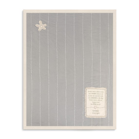A soft gray baby blanket with thin white stripes, a star patch, a sentimental message patch, and a beige lining.
