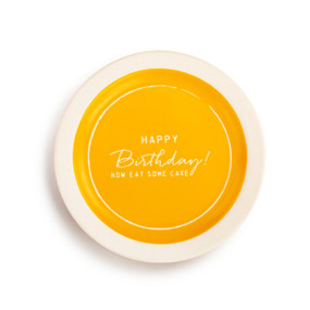 A small ivory plate, with a yellow center and reads Happy birthday! Now eat some cake' in ivory font."