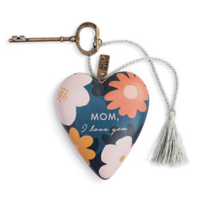 A blue art heart with several pink and orange flowers and reads Mom, I love you" in pink cursive letters. With a bronze key and a silver tassel."
