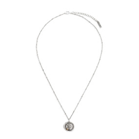 A dainty silver necklace with several silver knots on the chain, and a circular pendant with a gold heart and a tree engraved.