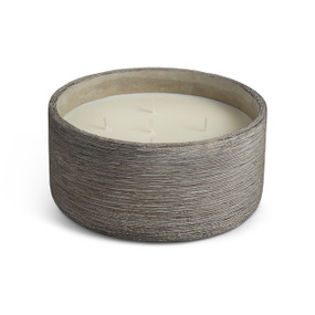 A front view of a large, circular, black washed, concrete candle. With 5 wicks.