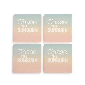 A set of four sunset colored square coasters that say "Chase the Sunburn" laid out on a white background.