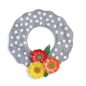 metal wall hanging painted and shaped like a gray wreath with white polka dots and three multicolor metal painted flowers at the bottom