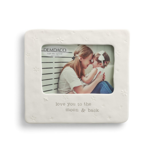 white ceramic frame with star imprints reading Love you to the moom & back