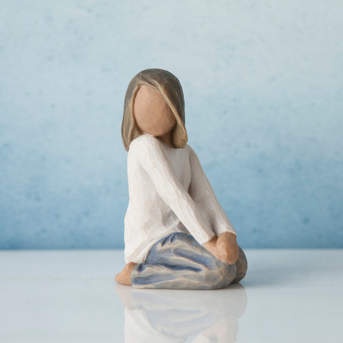 Little girl faceless figurine kneeling turning her head to the side - wearing white shirt and blue jeans