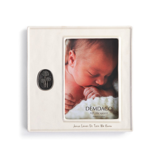 ceramic square photo frame reading Jesus Loves Us This We Know with silver metal emblem embossed with flowers stuck to left side