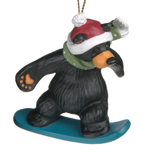 Black bear figurine on blue snowboard wearing red hat and green scarf