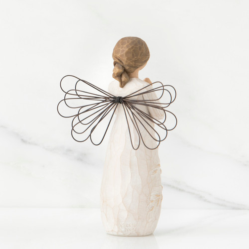 Back view of brunette girl figurine in white dress with brown wire wings standing up