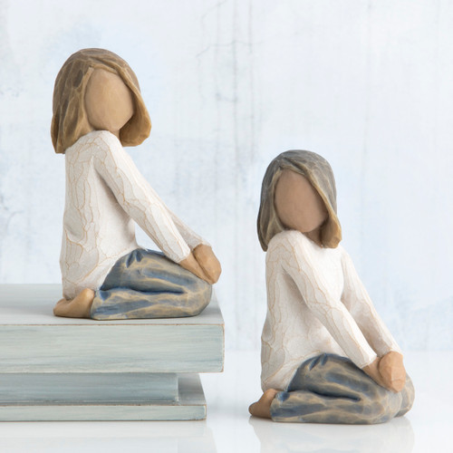 Set of two girl figurines sitting down in white shirts and blue jeans