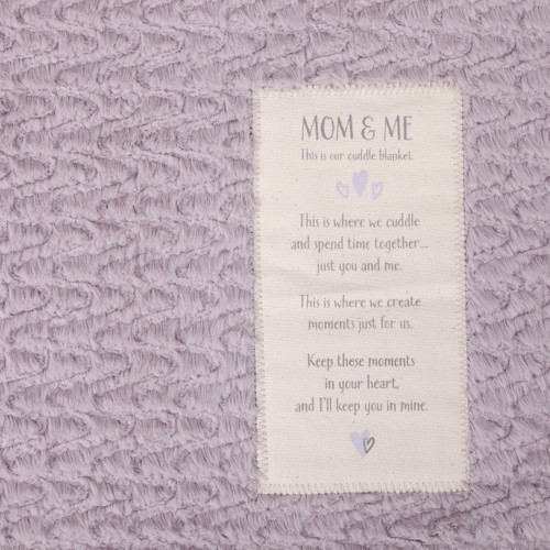 Light purple fabric with cream tag that says 'mom&me' carved in with long quote underneath