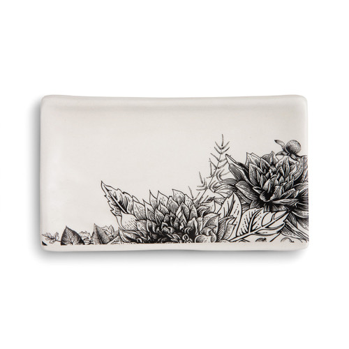 white rectangular ceramic dish with black flower designs in bottom right corner