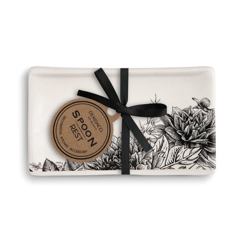 rectangular white ceramic spoon rest with black flower design wrapped with black ribbon and labelled