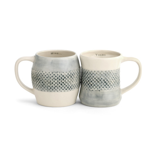 two mugs with blue and cream patterning that read 'mine…' and '…yours' on their inner rims