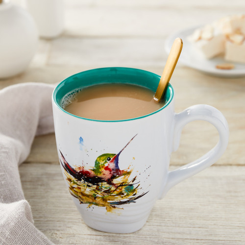 white ceramic mug with teal painted inside and watercolor flowers with coffee and stirring stick inside